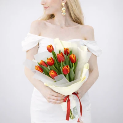 Букет из 9 желто-оранжевых тюльпанов в оформлении